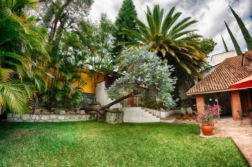 a house with a yard with palm trees at Hotel Casa Yunenisa in Oaxaca City