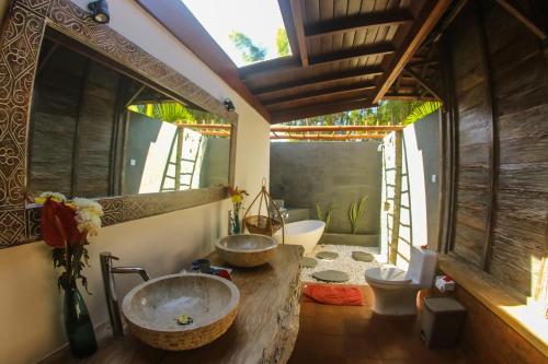 a bathroom with two sinks and a toilet at Flower Bud Bungalow Balangan in Jimbaran