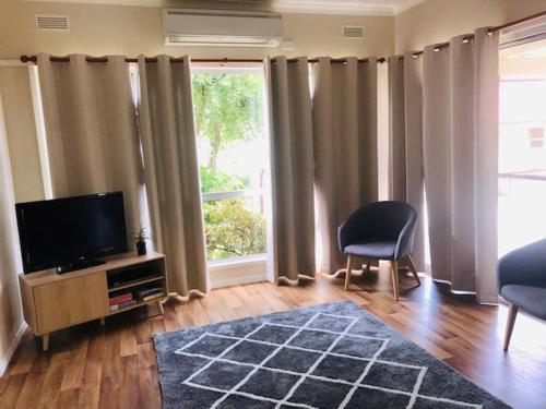 a living room with a tv and a large window at Villa Asolana in Myrtleford