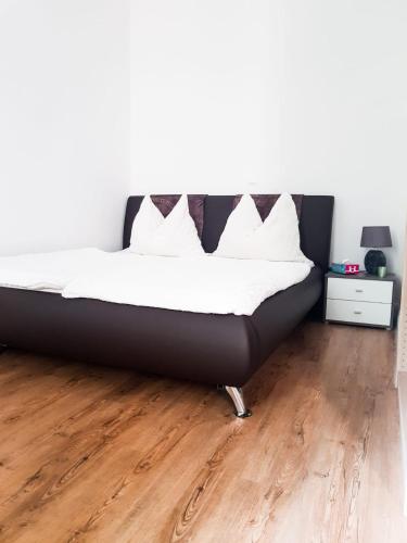 een bed in een kamer met een houten vloer bij Sonniges Studio Heinzelmanngasse in Wenen