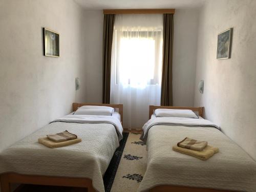 two twin beds in a room with a window at Apartman Jezerce 71 in Plitvička Jezera