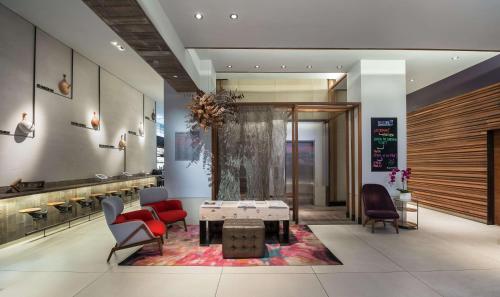 a lobby with chairs and a table in a room at Hyatt Herald Square New York in New York