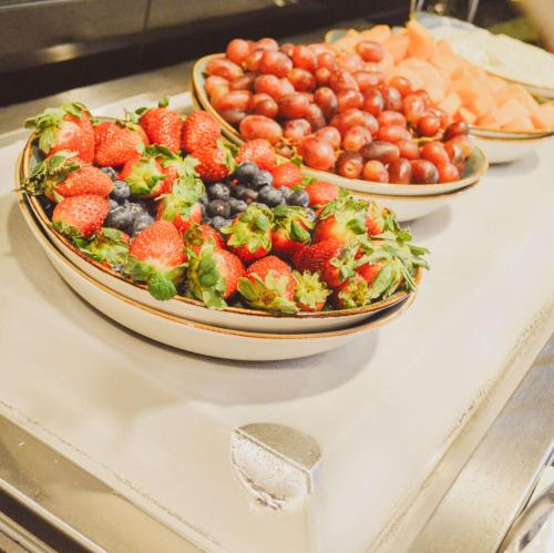 a plate of fruit on a counter with two bowls of fruit at Hyatt Place Salt Lake City Downtown / The Gateway in Salt Lake City