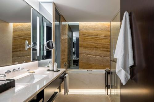 a bathroom with a tub and a sink and a mirror at Hyatt Regency Shanghai Global Harbor in Shanghai