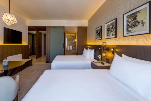 a hotel room with two beds and a television at Hyatt Regency Andares Guadalajara in Guadalajara