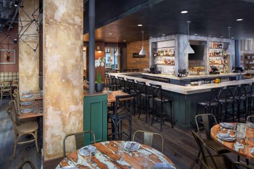 a restaurant with tables and chairs and a bar at Hyatt Centric Faneuil Hall Boston in Boston