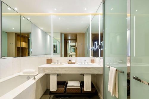 a bathroom with a sink and a tub and a mirror at Grand Hyatt Bogota in Bogotá