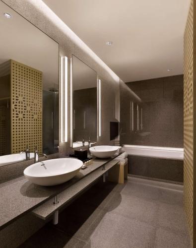 a bathroom with two sinks and two mirrors at Park Hyatt Busan in Busan