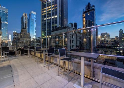 a balcony with tables and chairs on a city skyline at Hyatt Herald Square New York in New York