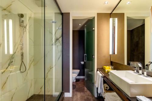a bathroom with a sink and a glass shower at Hyatt Centric Montevideo in Montevideo