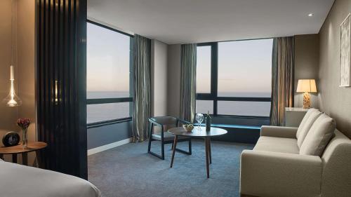 a hotel room with a bed and a couch and a table at Hyatt Centric Montevideo in Montevideo