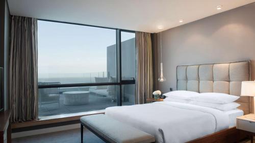 a bedroom with a white bed and a large window at Hyatt Centric Montevideo in Montevideo