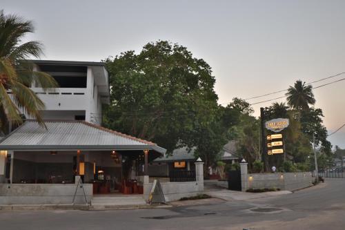 a building with a sign on the side of a street at Tangalle Rest House in Tangalle