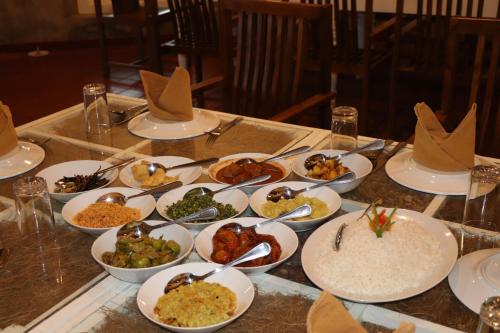 a table with plates of food on top of it at Tangalle Rest House in Tangalle