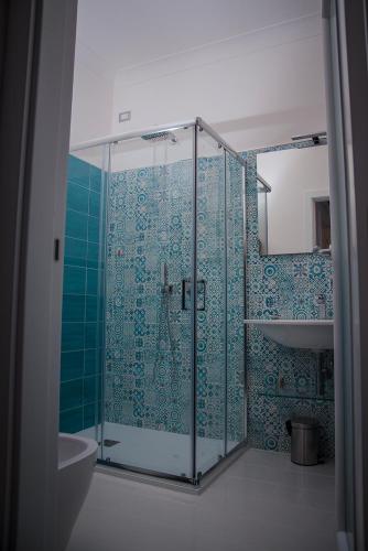a bathroom with a glass shower with blue tiles at B&B La Gemma di Ravello in Ravello