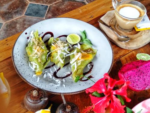 een bord eten met een salade op tafel bij Kubu Kangin Resort in Amed