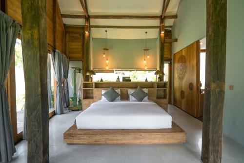 een slaapkamer met een groot bed in een kamer bij Insana Villa in Gili Trawangan