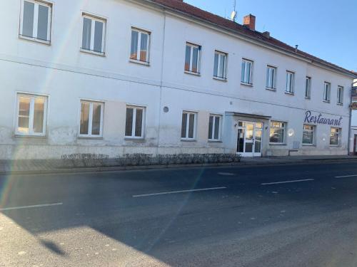 a white building on the side of a street at Penzion Mánes in Krabčice