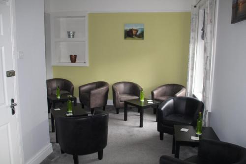 a waiting room with leather chairs and tables at The Kenbury B&B in Shanklin