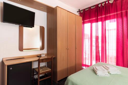 a hotel room with a bed and a television at Hotel Palace in Finale Ligure