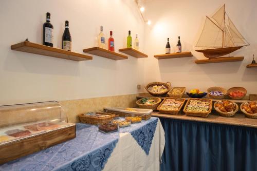 un buffet con una mesa con comida y botellas de vino en Hotel Palace, en Finale Ligure