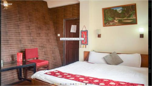a bedroom with a bed and a red chair at Pahari Soul in Darjeeling