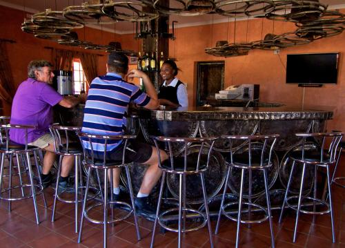 a group of people sitting at a bar at Kashana Namibia in Omaruru
