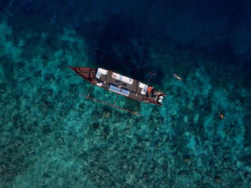 um barco flutuando na água sobre o oceano em Pondok Santi Estate em Gili Trawangan