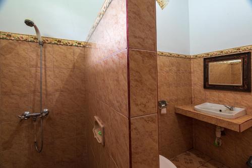 a bathroom with a shower and a sink at Pondok Wisata Sartaya 2 in Lovina