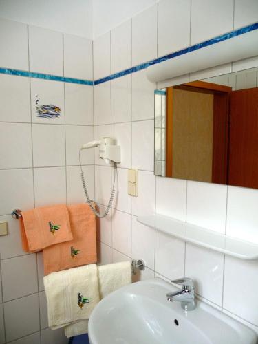 a bathroom with a sink and a mirror and towels at Landhaus Sonnentau in Johanngeorgenstadt