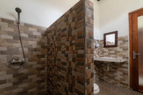a bathroom with a toilet and a sink at Pondok Wisata Sartaya 2 in Lovina