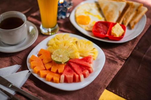 two plates of breakfast food with fruit on a table at Pondok Wisata Sartaya 2 in Lovina