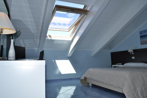a bedroom with a bed and a skylight at Hotel Murmann in Maratea
