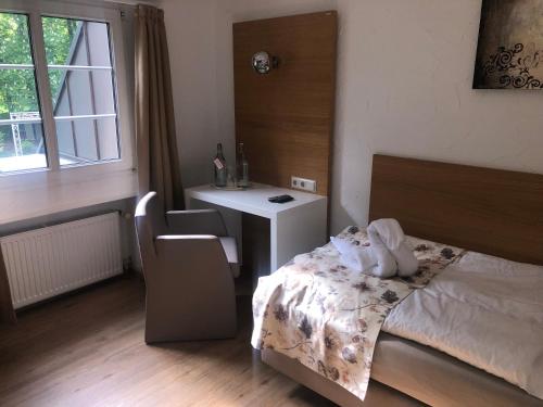 a bedroom with a bed and a desk and a chair at Hotel & Gastropark Loemühle in Marl