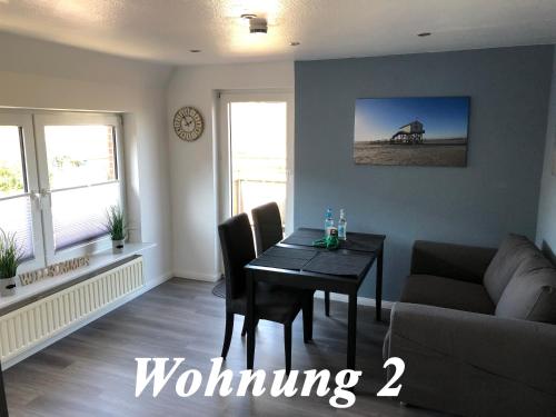 a living room with a table and a couch at Haus Waldenfels in Sankt Peter-Ording