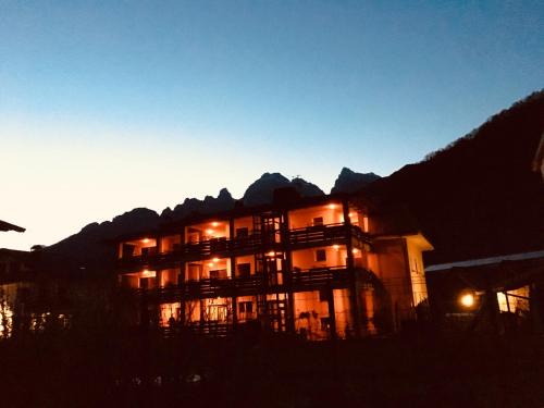 a building with the mountains in the background at Residenza La Ciasa in Claut