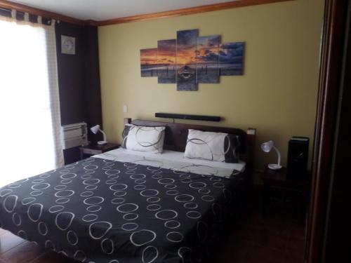 a bedroom with a bed and a painting on the wall at Sailfishbay Surf And Big Game Fishing Lodge in San Isidro