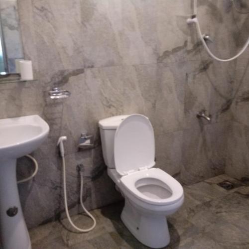 a bathroom with a toilet and a sink at Unawatuna Backpacker Lodge in Unawatuna