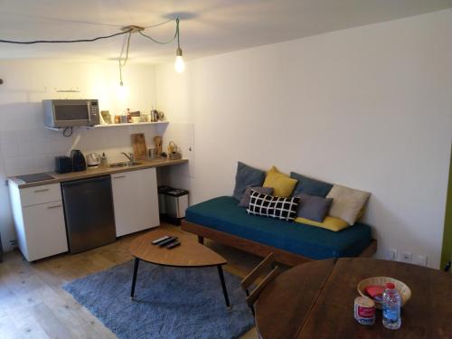 a living room with a blue couch and a kitchen at Tour Duguesclin in Chauvigny