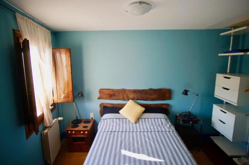 a blue bedroom with a bed with a blue wall at Cal Talaia in La Glorieta