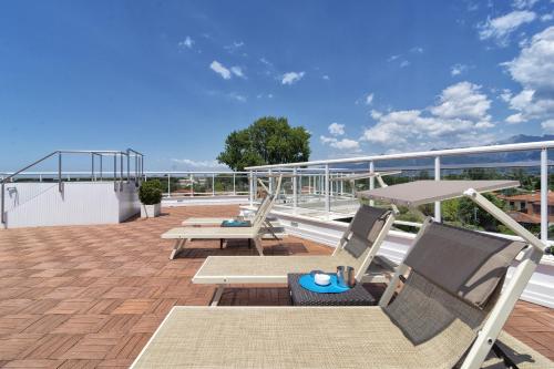 a balcony with chairs and tables on a roof at Hotel Central Park in Marina di Pietrasanta