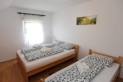 two twin beds in a room with a window at Teo-Sport in Cerovac