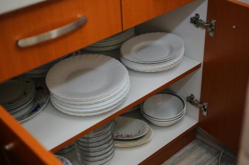 a cabinet filled with plates and dishes on a shelf at Teo-Sport in Cerovac