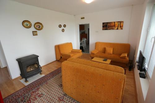 a living room with a couch and a stove at Teo-Sport in Cerovac
