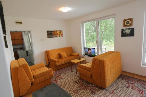 a living room with two chairs and a television at Teo-Sport in Cerovac