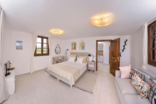 a white bedroom with a bed and a couch at CENTER Penthouse - MEDIEVAL Town 10'- BEACH 2' in Rhodes Town