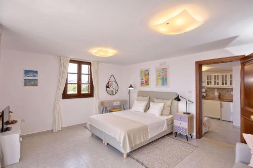 a bedroom with a white bed and a kitchen at CENTER Penthouse - MEDIEVAL Town 10'- BEACH 2' in Rhodes Town
