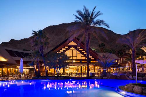 a resort with a swimming pool at night at Orchid Eilat Hotel in Eilat