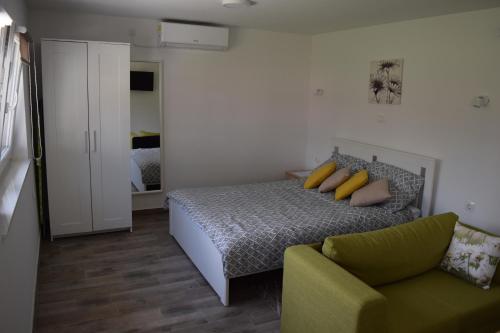 a bedroom with a bed and a couch at A&M studio apartman in Otočac
