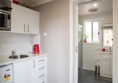 a white kitchen with a sink and a window at Rivershack Pet Friendly in Renmark